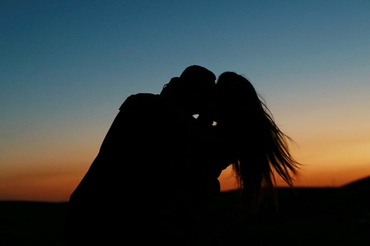 Royalty-Free photo: Silhouette of couple kissing during golden hour ...
