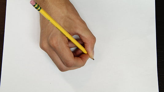person holding yellow pencil on white paper