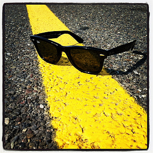 black framed Ray-Ban Wayfarer sunglasses on road