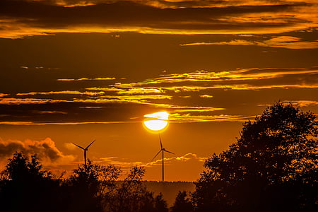 two windmill turbines under clouds golden hour photography