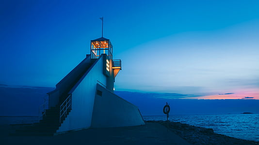 lighted guardhouse near sea at night