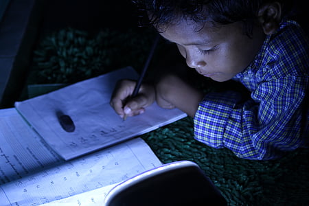 boy writing on white paper