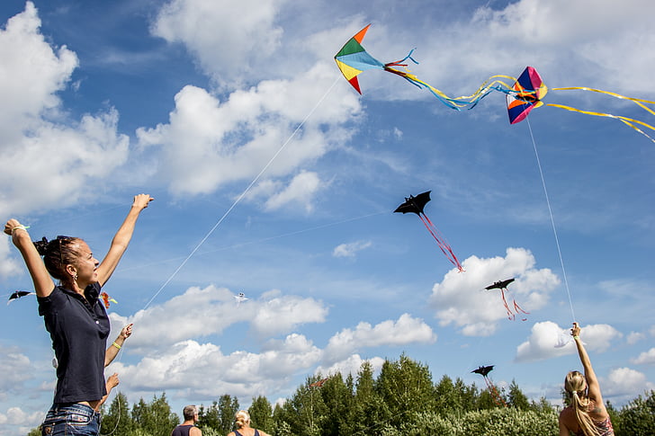 woman holding playing paper kite under cloudy blue sky during daytime