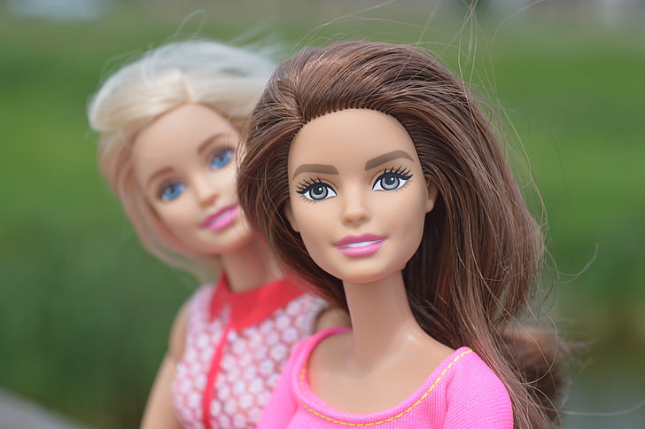 macro photography of two Barbie dolls