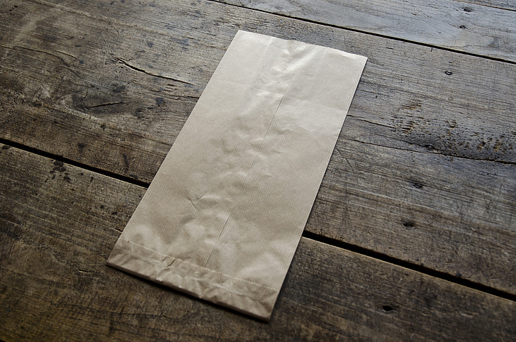 brown paper bag on wooden surface