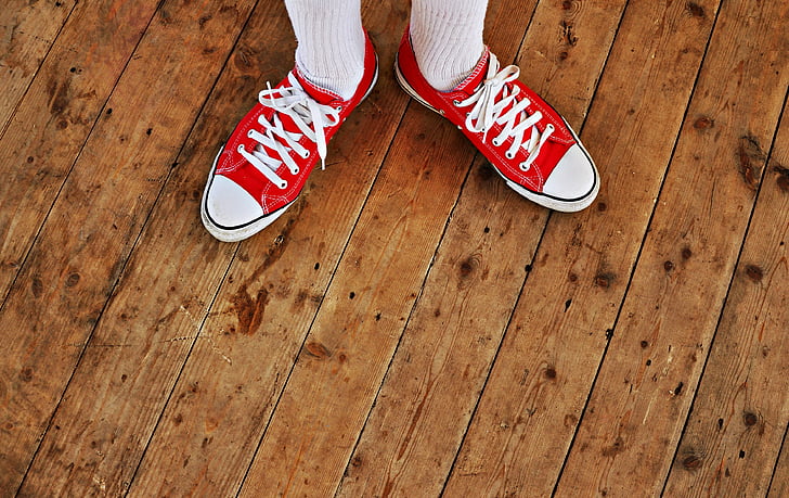 person wearing red-and-white low-top sneakers