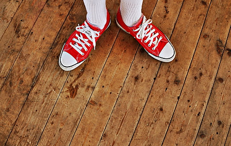 person wearing red-and-white low-top sneakers