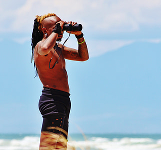 man using binoculars at daytime