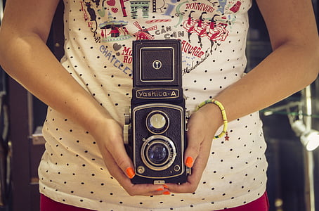 woman holding black Yashico-A reflex camera