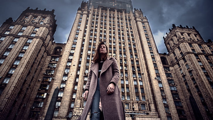 HRD photography of woman standing in front of high-rise building during daytime