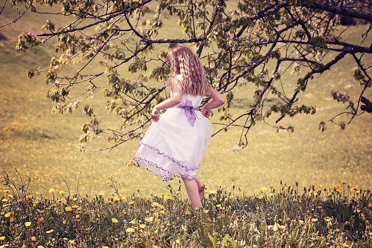 girl in pink playing on grass field