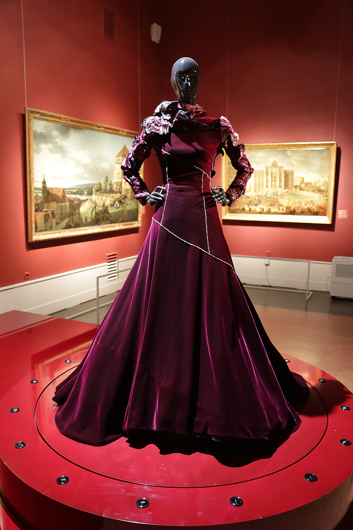 mannequin wearing burgundy velvet gown on display