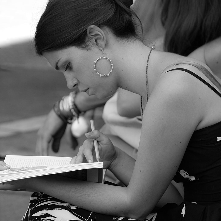 grayscale photo of woman with white book