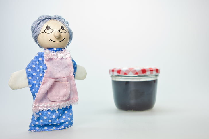 grandma doll beside clear glass container