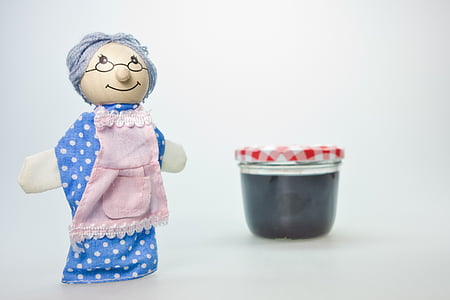 grandma doll beside clear glass container