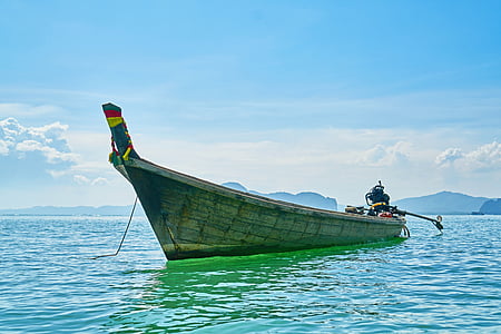 gray wooden outboard boat on body of water