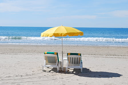 two adirondack chairs on the beach
