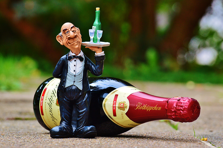 butler figurine beside wine bottle
