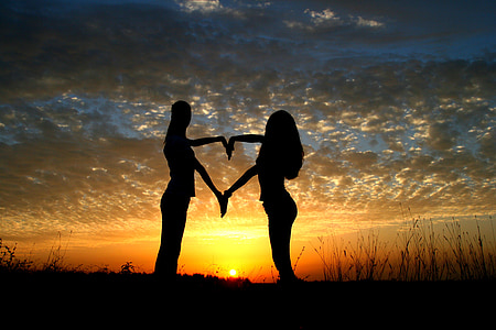 silhouette photo of a man and woman on sunset