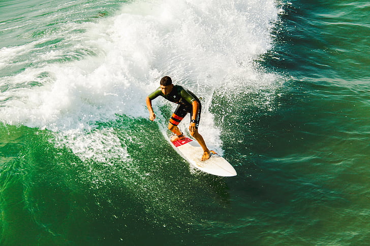 male surfer on white surfboard riding on tidal wave