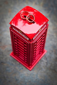 red and gray telephone booth coin bank and two silver-colored rings