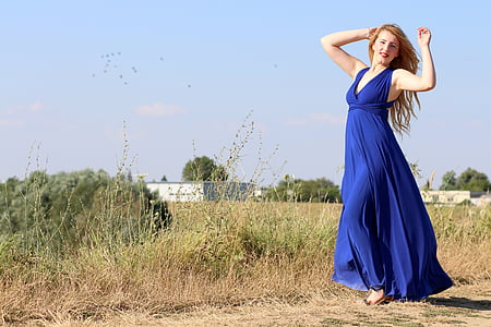 woman wearing blue halter dress beside grasses