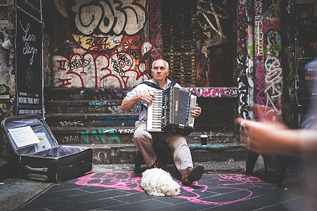 man wearing in white shirt playing accordion