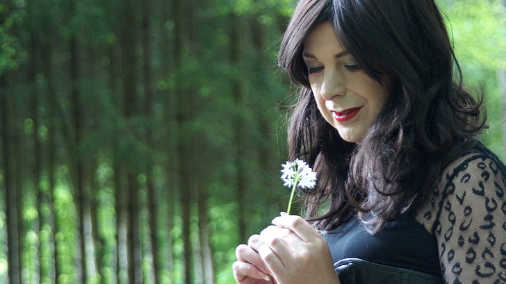 woman holding white petaled flower during daytime