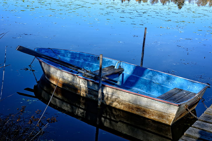 blue and brown canoe on water during daytime