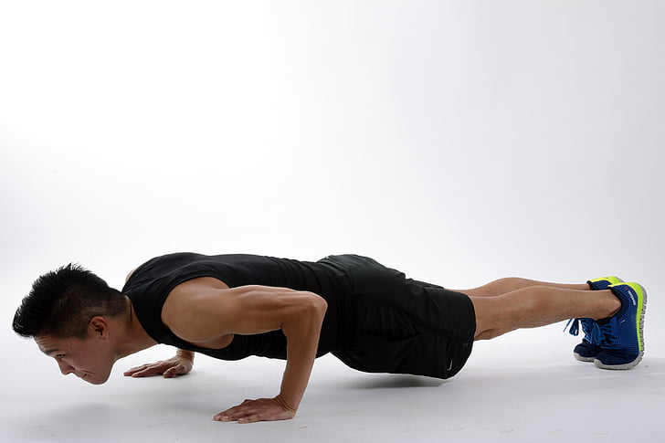 man wearing black sleeveless shirt doing push ups