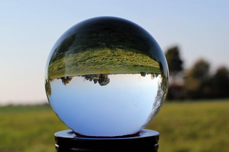 clear crystal ball near green grass field