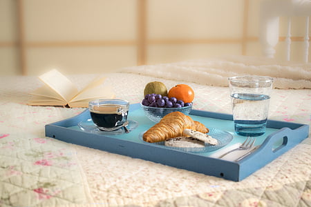 assorted fruits, two clear drinking glasses with liquids, and pie on blue wooden tray