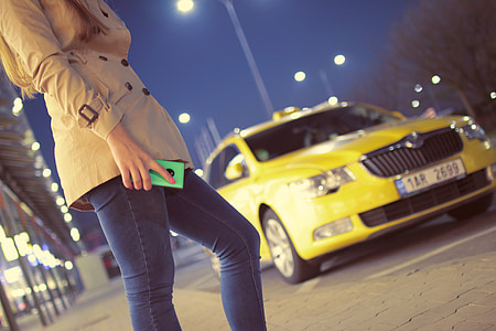 woman wearing brown coat near yellow car