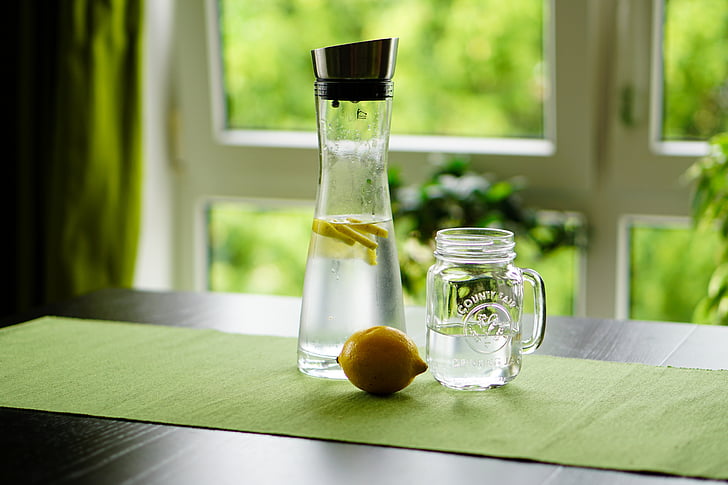 shallow focus photography of sliced lemon in glass bottle with water