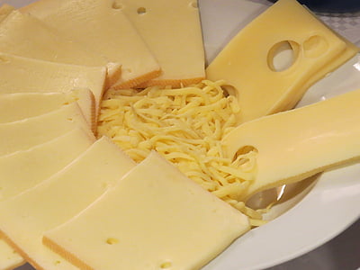sliced and grated cheese on round white ceramic bowl