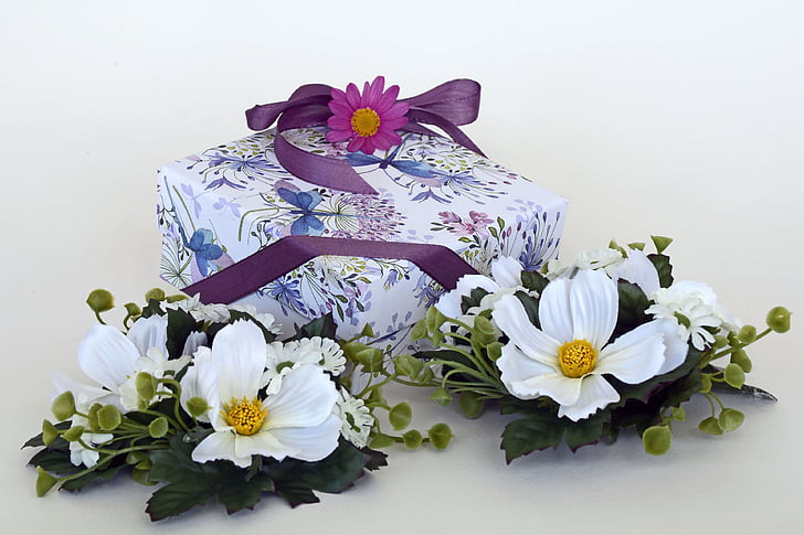 white petaled flowers beside purple box