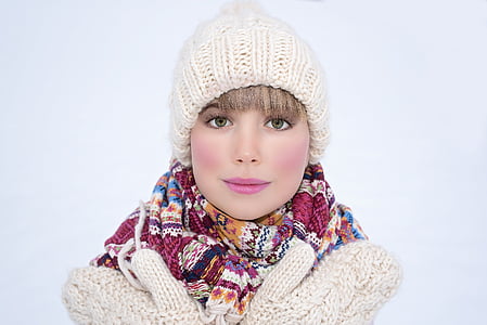 woman in white jacket wearing knit beanie and floral scarf