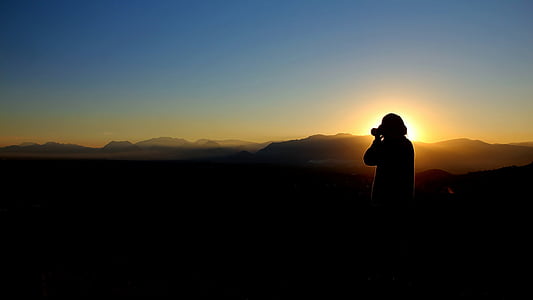 silhouette photo of person holding camera