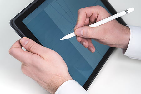 person writing in a tablet computer using stylus