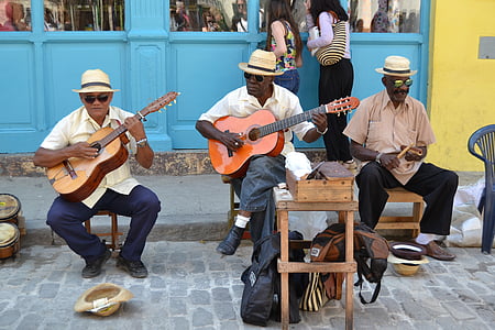three man playing instrument on road