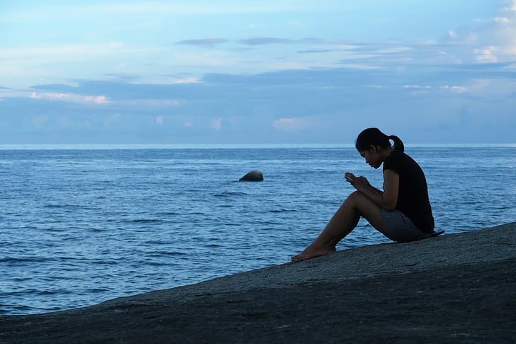 woman sitting beside seashore