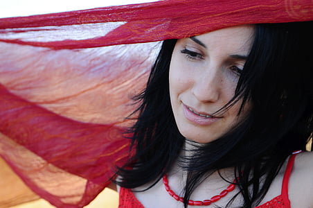 woman smiling under red textile