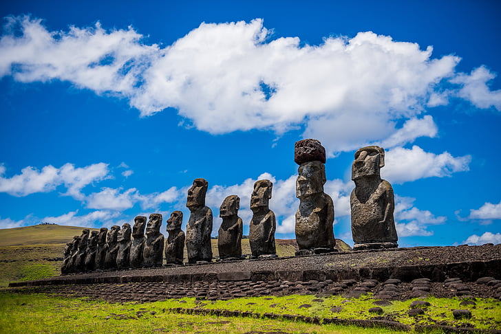 Moai statues under blue and white cloudy skies at daytime