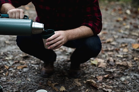 person holding green thermos