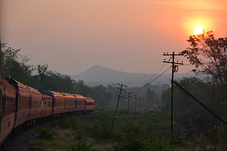 gray locomotive train passing near electric post during golden hour