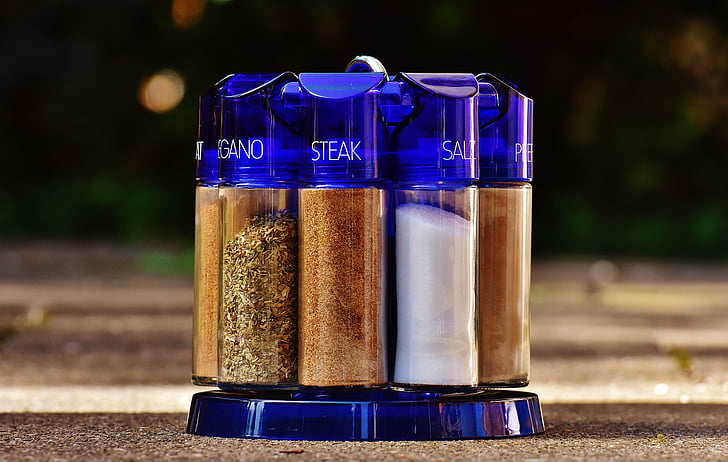 purple glass spice rack with condiments on brown surface