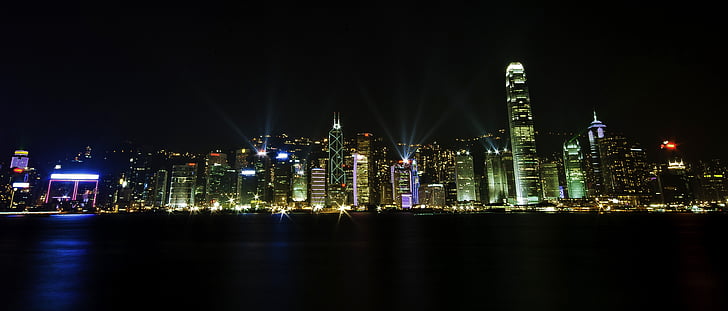 panorama photography of lighted high-rise buildings nearby sea