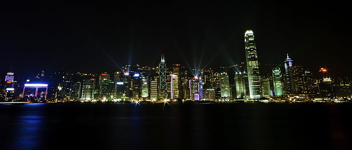 panorama photography of lighted high-rise buildings nearby sea