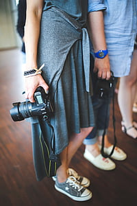 woman wearing gray holding DSLR camera