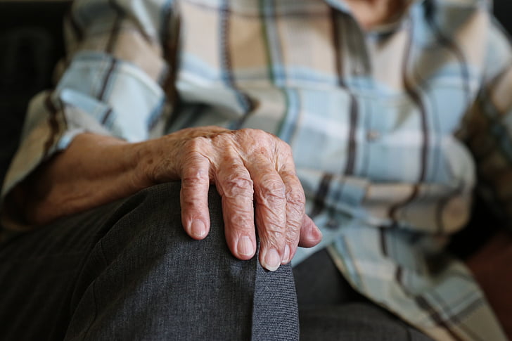 selective focus photo of person with wrinkled hand